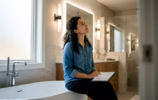 Interior designer evaluating layered bathroom lighting